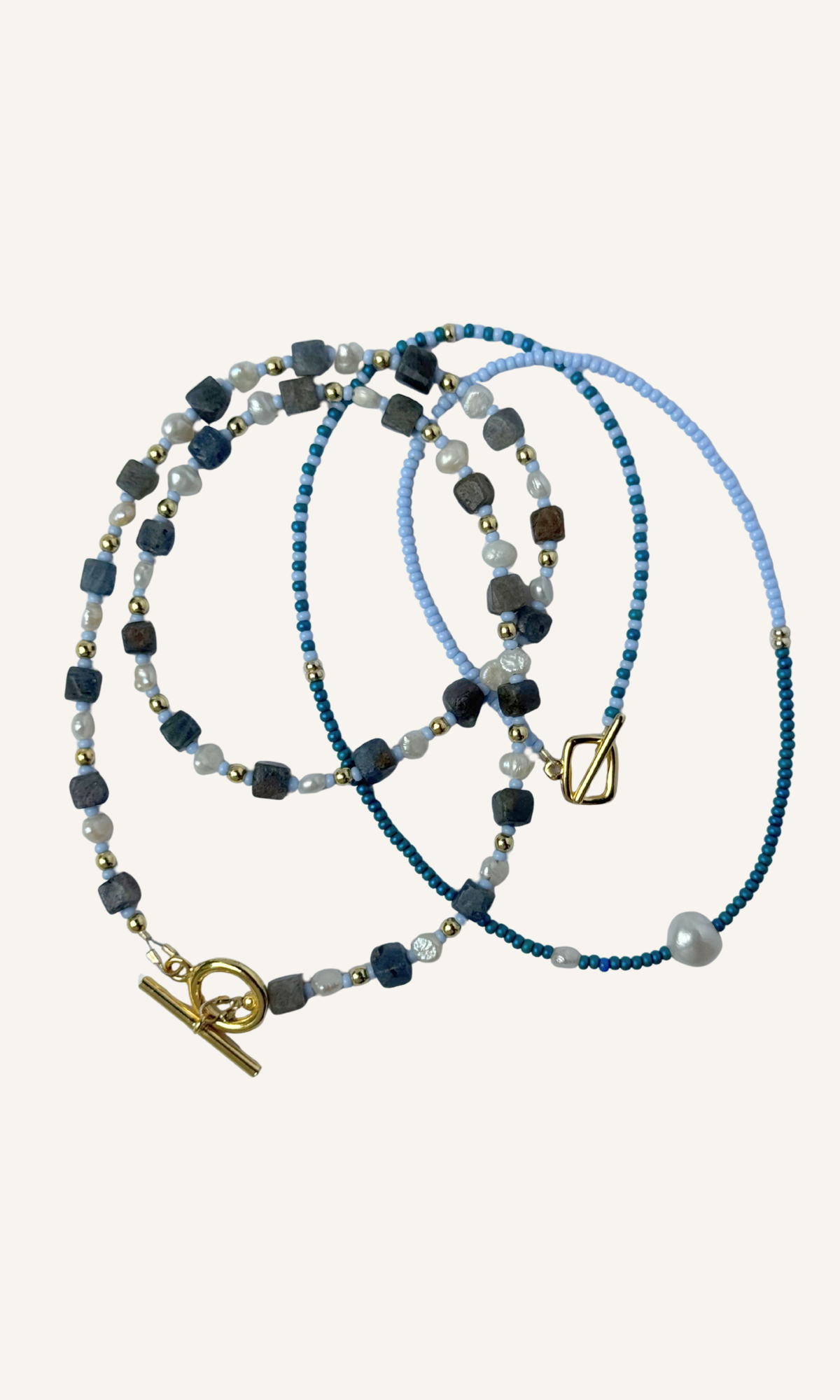 Cubed Sapphire and tiny Freshwater Pearl necklace with light blue and gold spacer beads, gold filled findings, and a toggle closure and blue seed bead color block necklace with two freshwater pearls