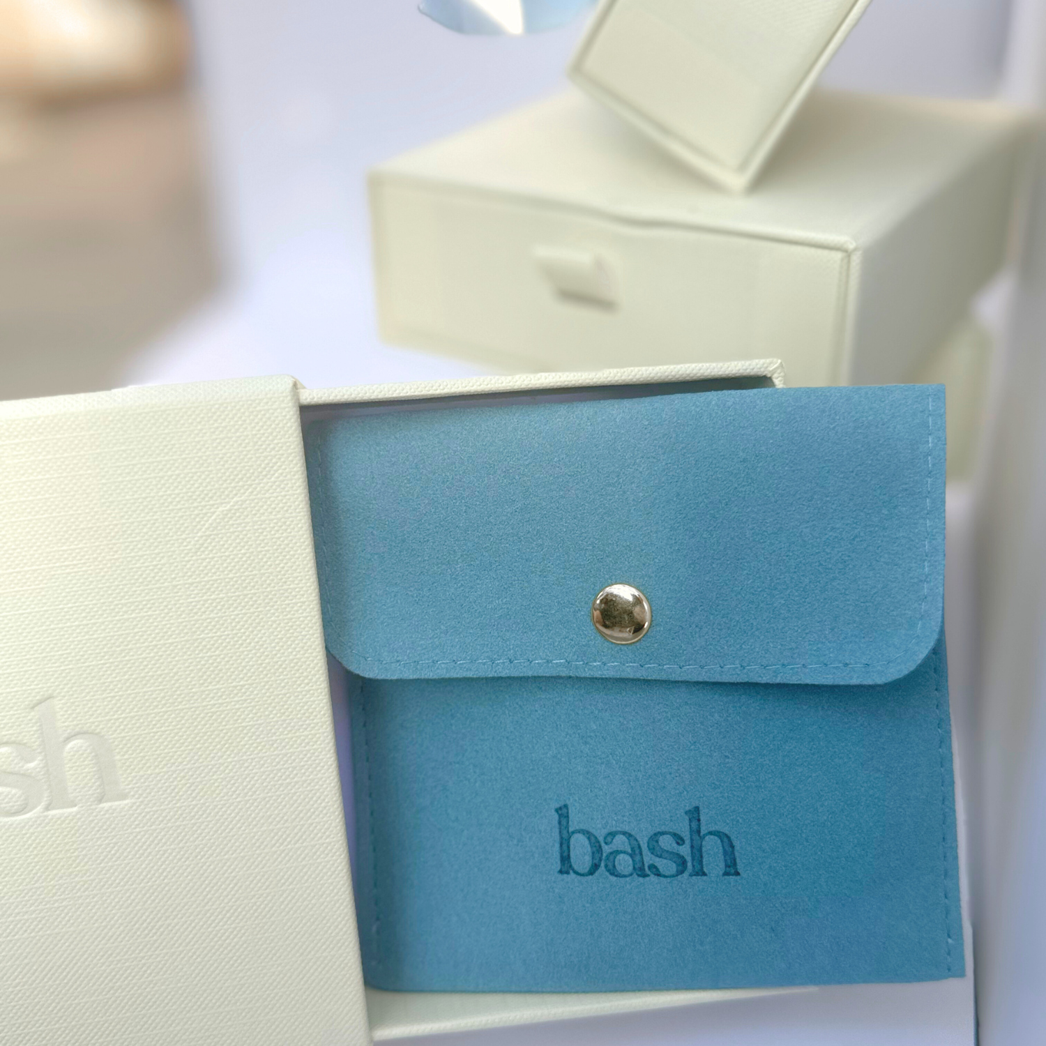 ivory gift box with Bash logo and pull out drawer with blue Bash pouch inside to hold jewelry
