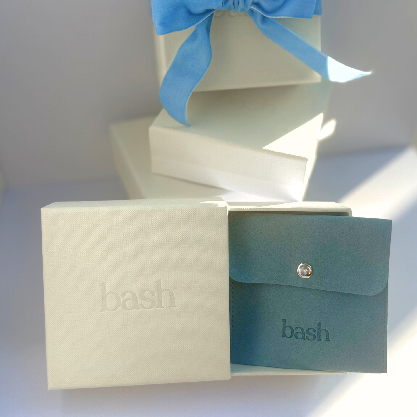ivory gift box with Bash logo and pull out drawer with blue Bash pouch inside to hold jewelry