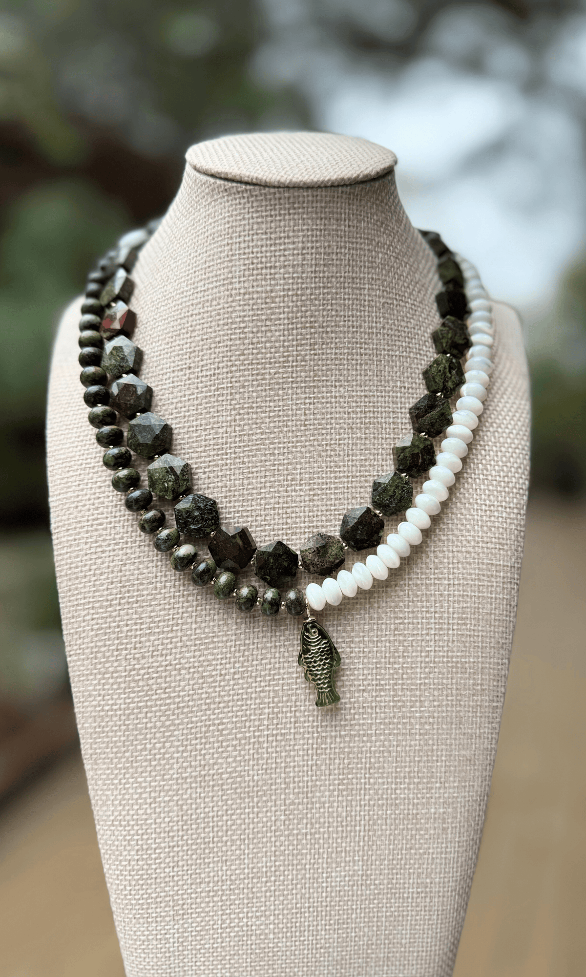 Dark green Dragon Blood Jasper necklace with hexagon shaped stones, gold spacer beads, gold filled findings, and a hook clasp and dark green jasper and mother of pearl necklace with green fish charm and gold filled findings