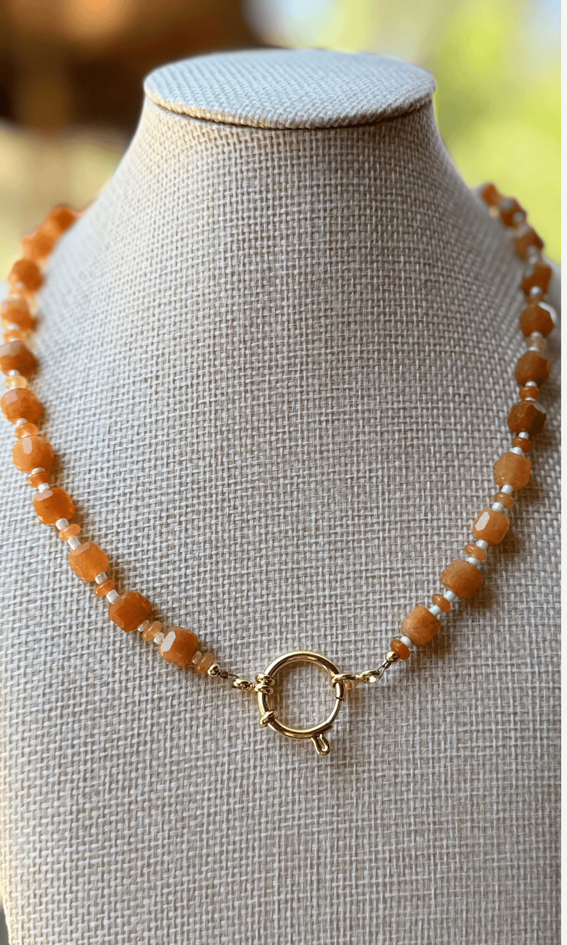 Orange Aventurine gemstones in various sizes with white spacer beads, gold filled findings, and a sailor clasp
